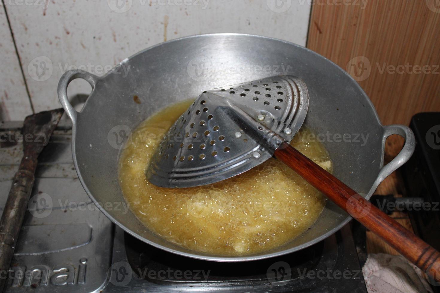 il padella è frittura il patate su il stufa foto