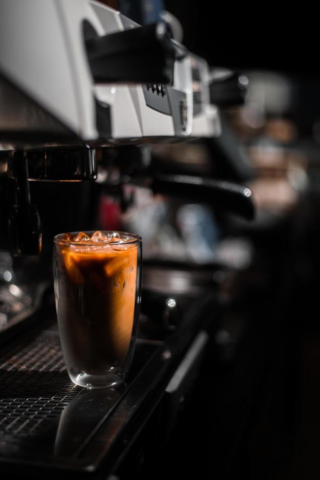 primo piano bicchiere di caffè freddo con latte sul tavolo foto