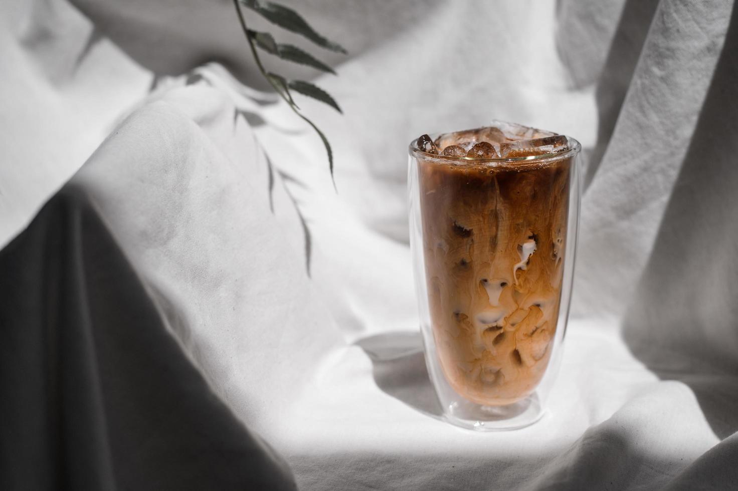 primo piano bicchiere di caffè freddo con latte sul tavolo foto