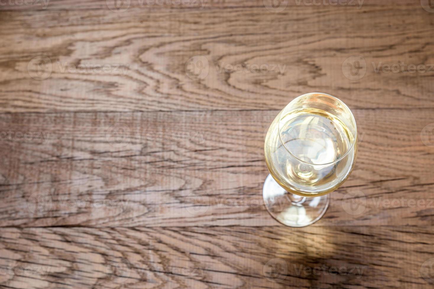 bicchiere con bianca vino su il di legno sfondo foto