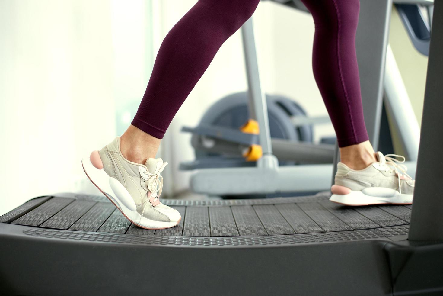 ragazze gambe nel leggero scarpe da ginnastica su un inerziale tapis roulant. foto