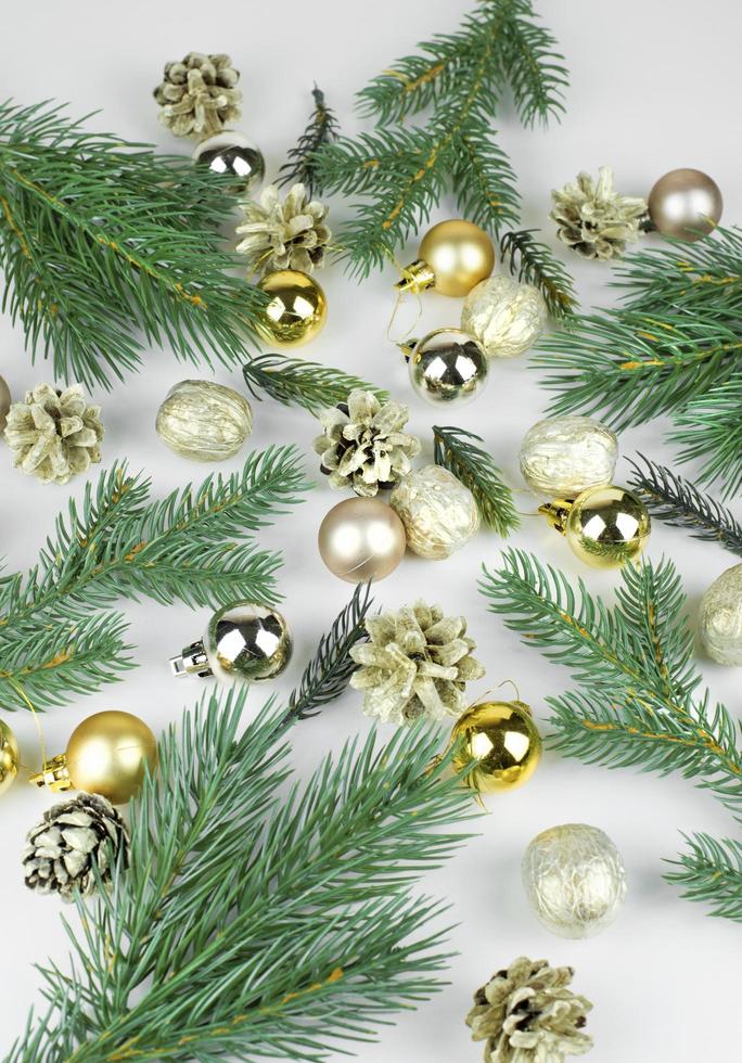 d'oro Natale palle, d'oro coni e rami di Natale albero su leggero sfondo foto