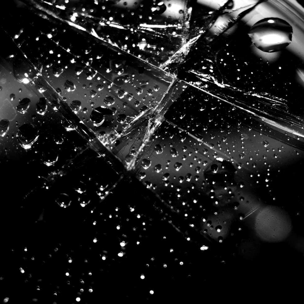 sfondo nero minimalista con crepe sul vetro con gocce d'acqua. minimalismo nero astratto. foto