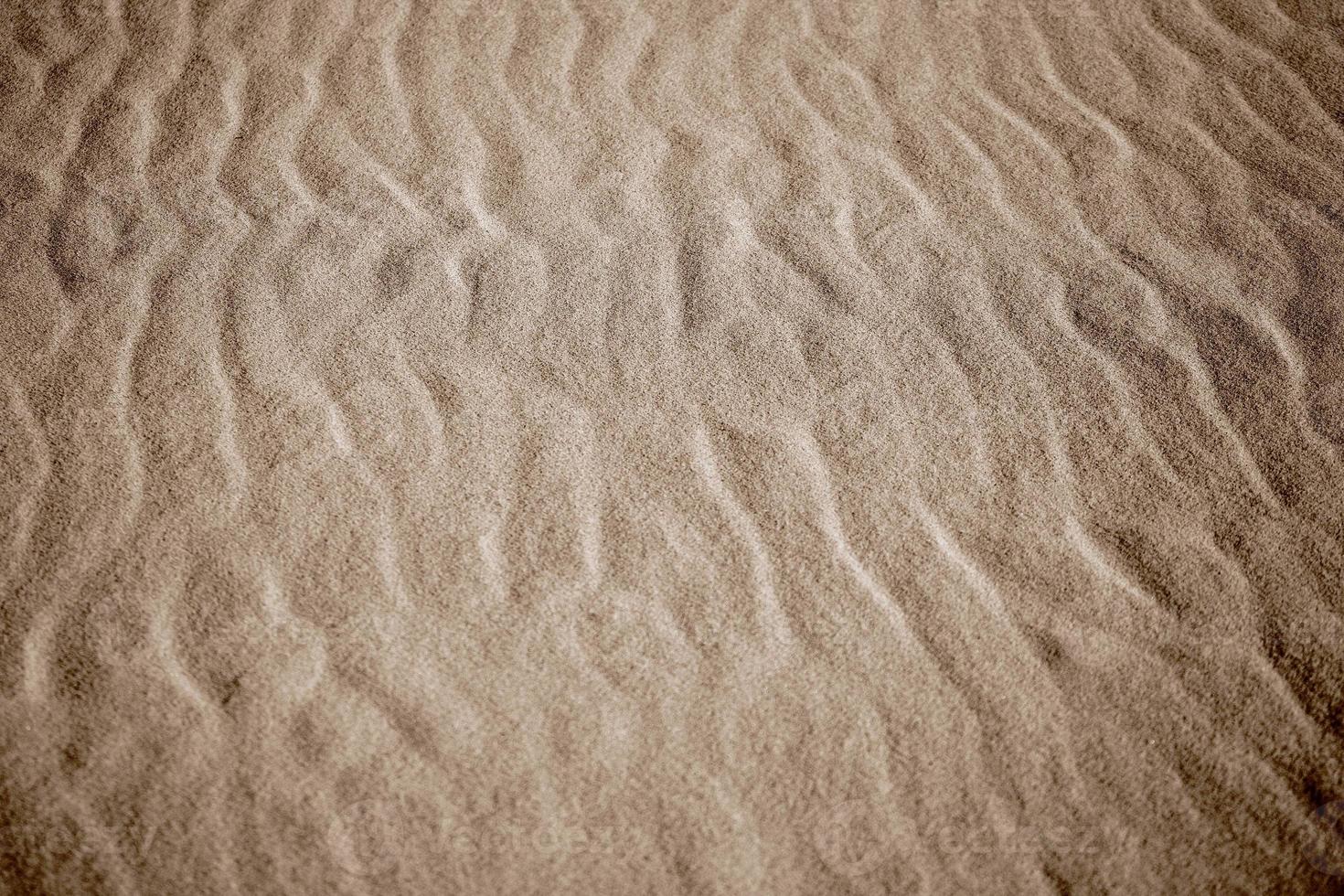 beige sfondo con sabbia nel il forma di sabbia onde foto