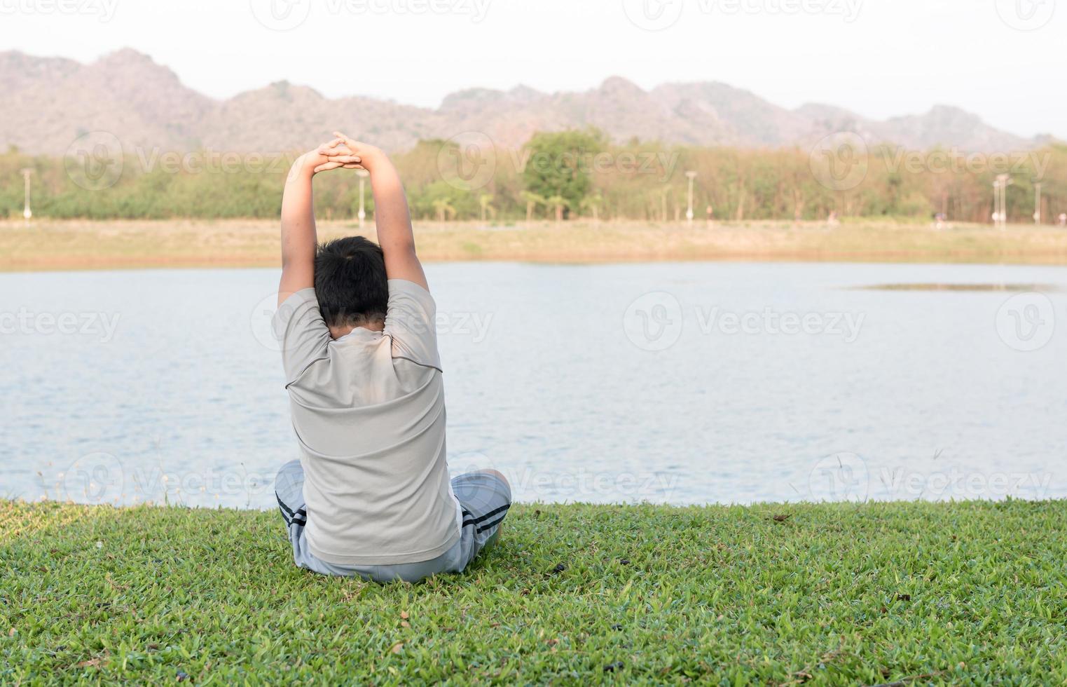 obeso Grasso ragazzo giocare yoga o esercizio su verde erba. foto