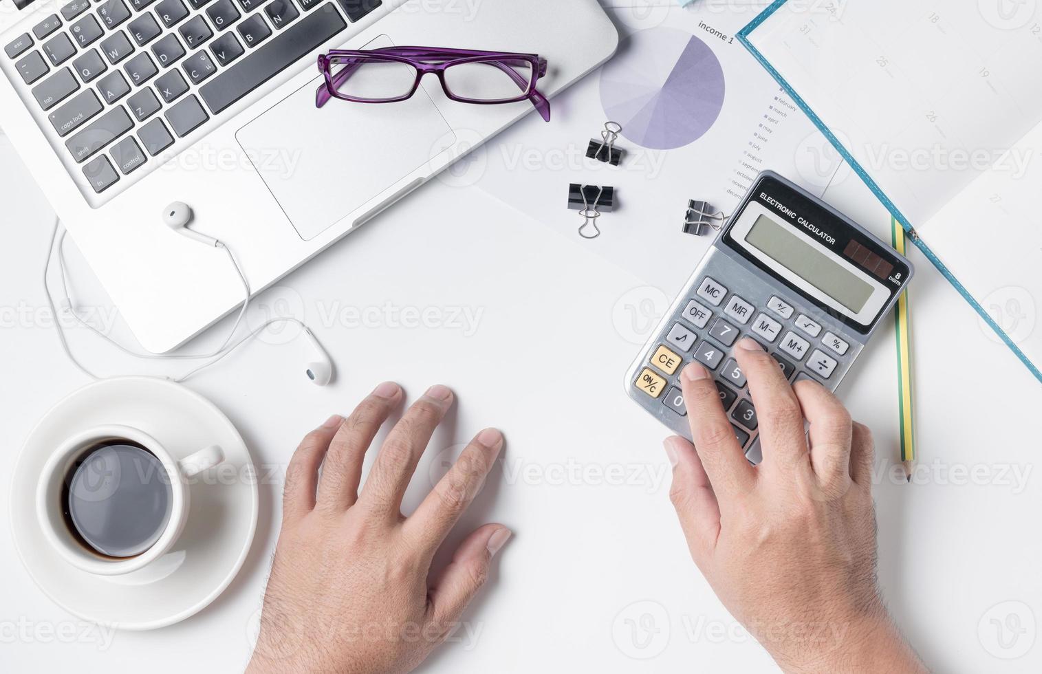 attività commerciale uomo utilizzando calcolatrice su moderno bianca ufficio scrivania tavolo foto