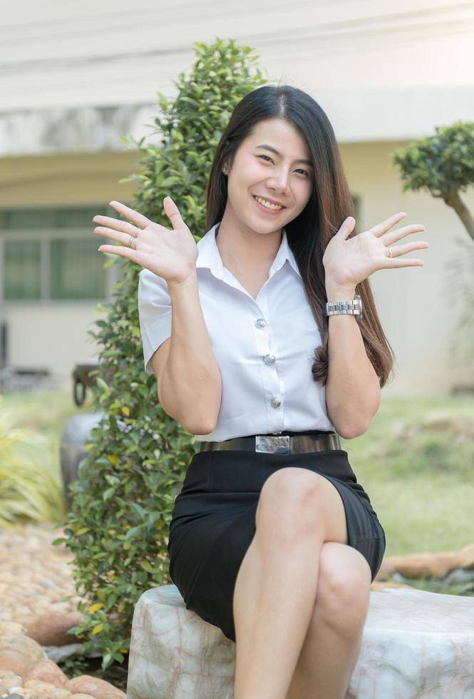 carino giovane asiatico donna nel uniforme alunno Sorridi foto