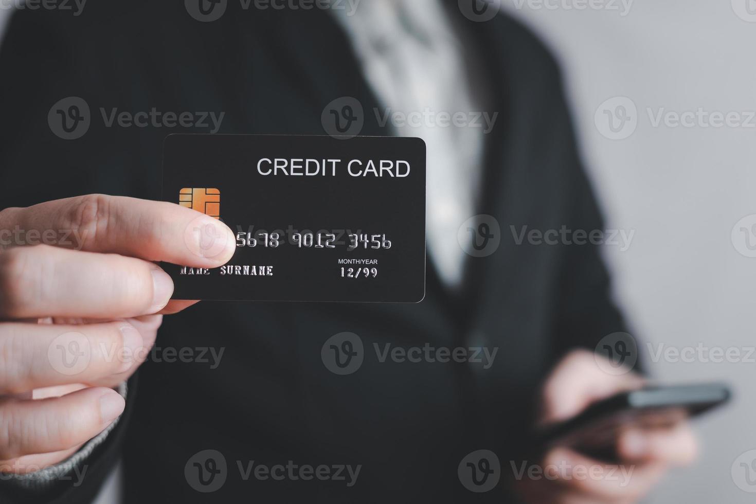 uomo d'affari mostrando un' modello credito carta per shopping per rendere pagamento e smartphone.metà corpo. concetto per striscione, Acquista, commercio, finanziario, carta, i soldi, utilizzando tecnologia. selettivo messa a fuoco. foto