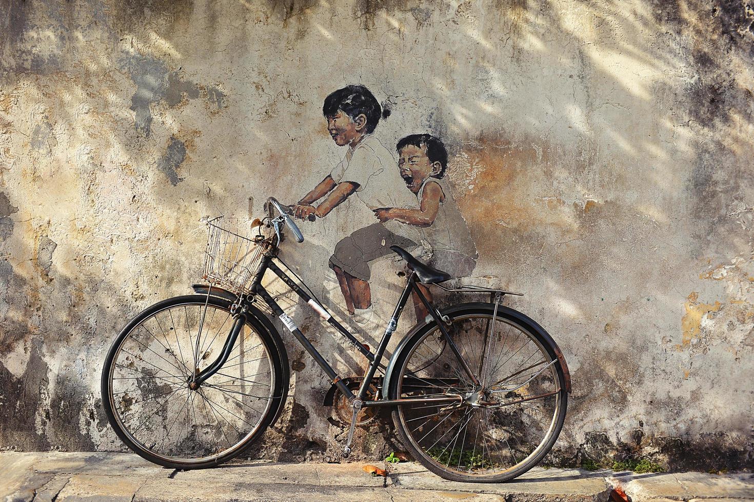 penang, Malaysia - luglio 18, 2014-strada murale intitolato 'piccolo bambini su un' bicicletta' dipinto di Ernesto zacharevic nel Penang su giugno 15, 2013. foto