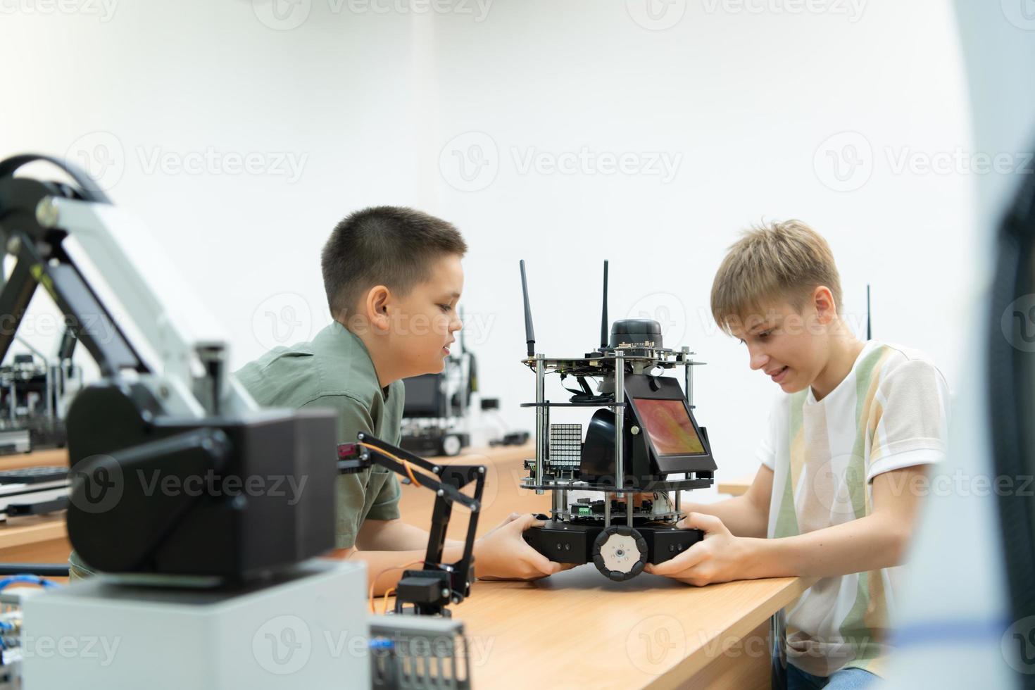 bambini utilizzando il mano robot tecnologia, studenti siamo studiando tecnologia, quale è uno di il stelo corsi. foto