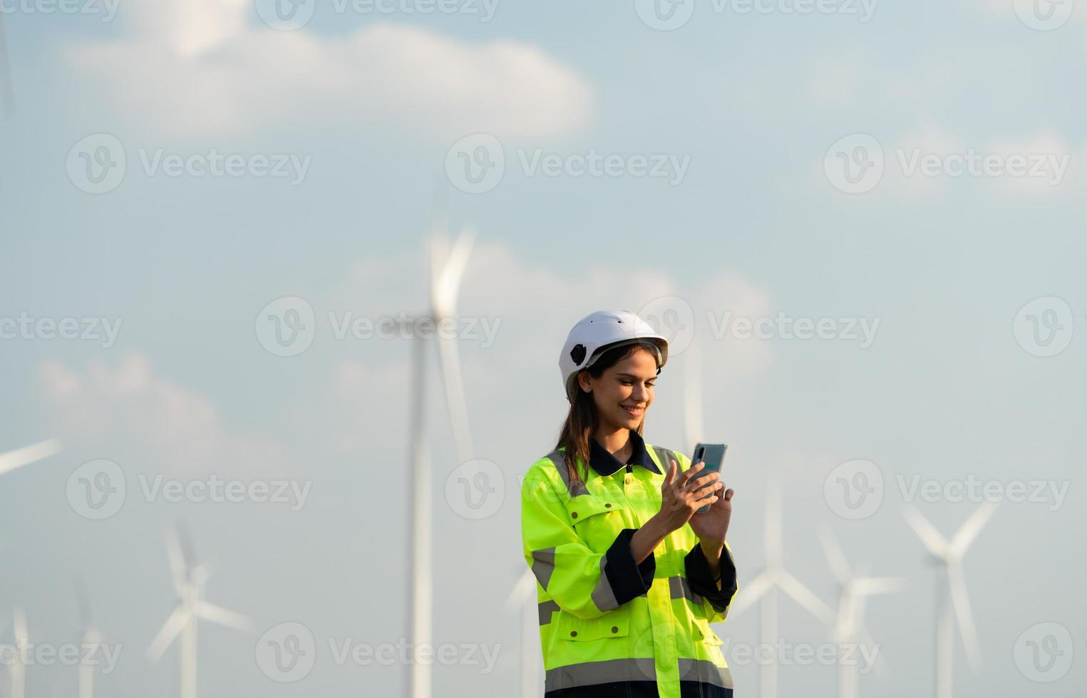 femmina ingegnere a naturale energia vento turbina luogo con il missione di essere responsabile per assunzione cura di grande vento turbine uso il Telefono per comunicare con il tuo famiglia per ottenere sbarazzarsi di mancante voi foto