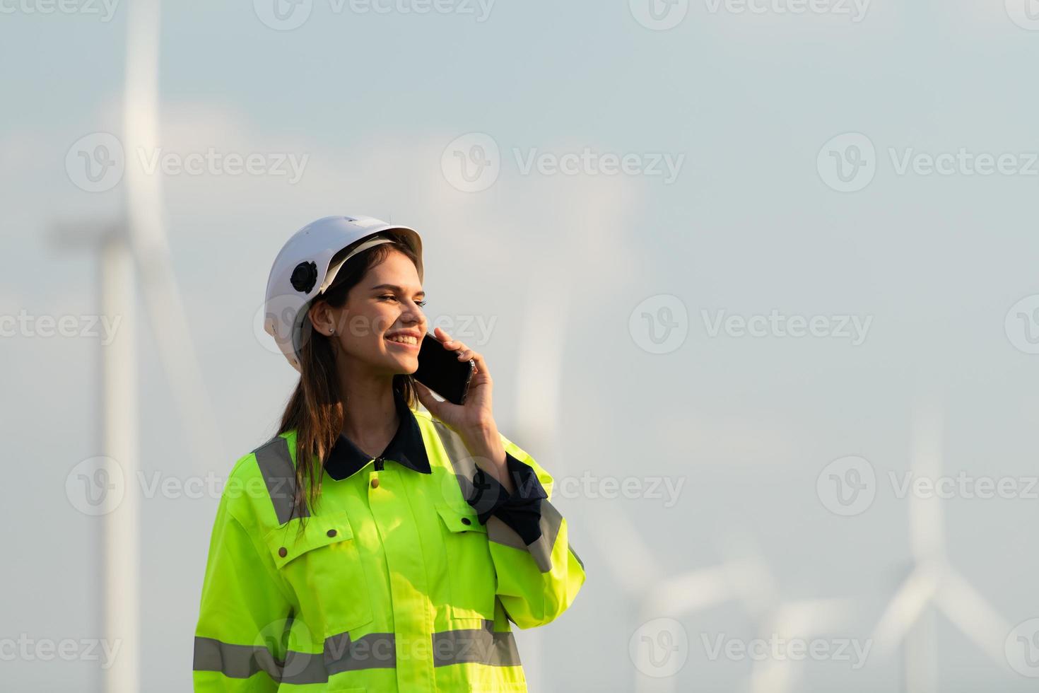 femmina ingegnere a naturale energia vento turbina luogo con il missione di essere responsabile per assunzione cura di grande vento turbine uso il Telefono per comunicare con il tuo famiglia per ottenere sbarazzarsi di mancante voi foto