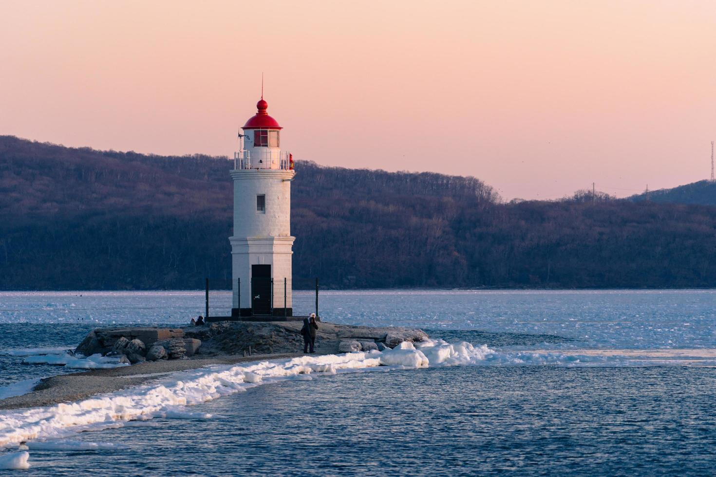 faro bianco con tetto rosso a vladivostok, russia foto