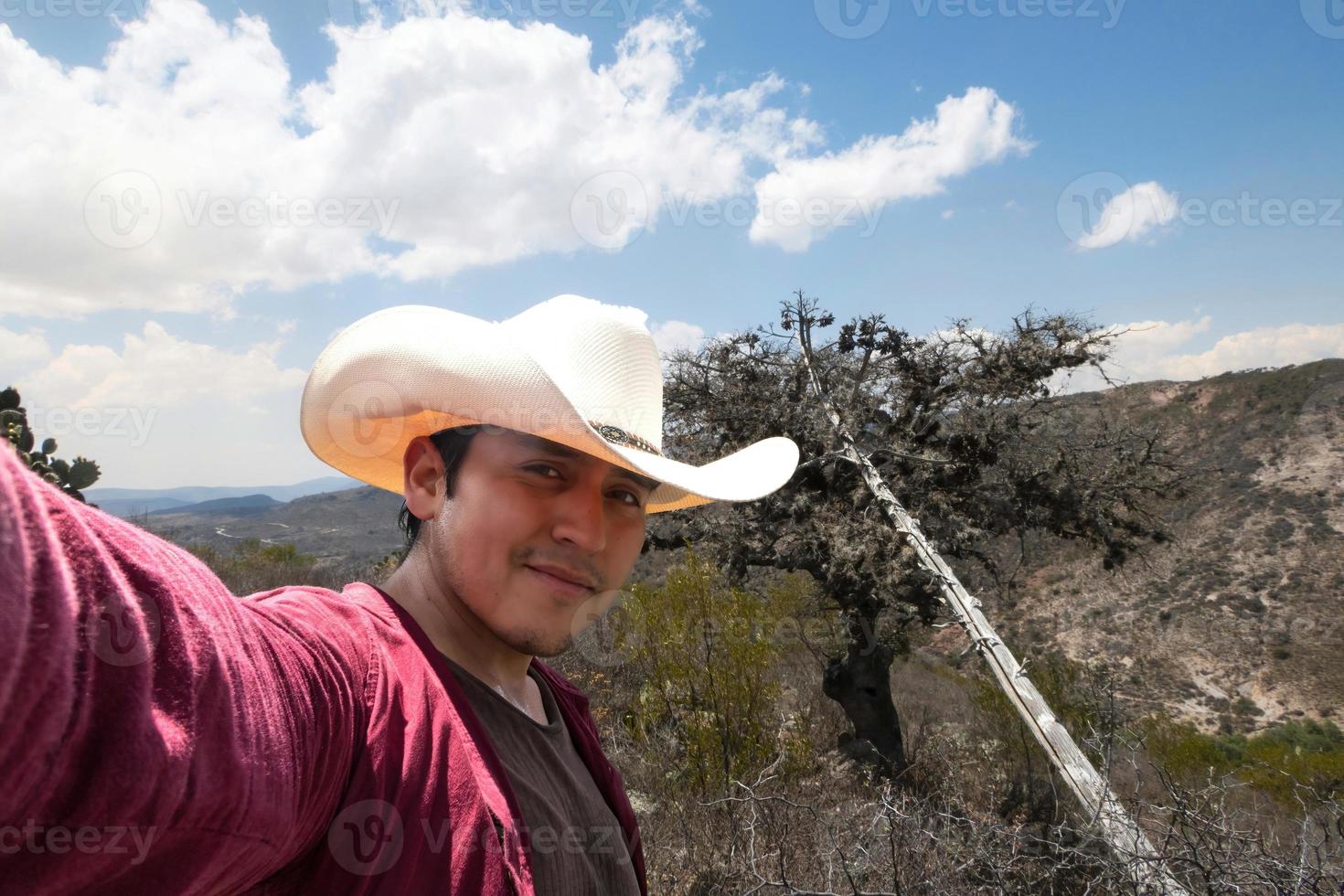 uomo nel un' cowboy cappello prende un' autoscatto nel davanti di un' montagna. foto