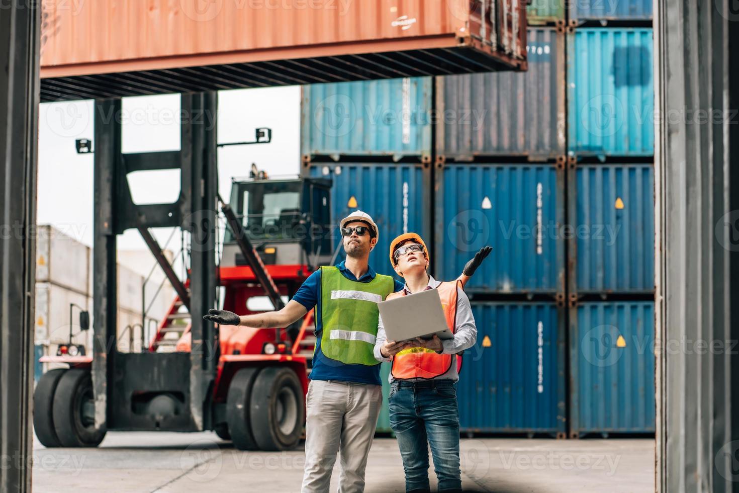 squadra ingegnere e lavoratore indossare sicurezza uniforme dai un'occhiata controllo Caricamento in corso nolo carico contenitore uso computer il computer portatile a commerciale bacino magazzino, trasporto importare, esportare logistica industriale servizio foto