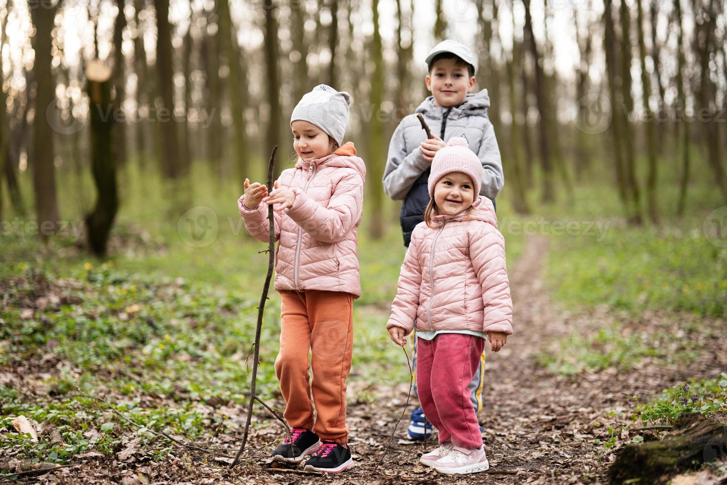 tre bambini escursioni a piedi e scoprire primavera foresta. contento infanzia. foto