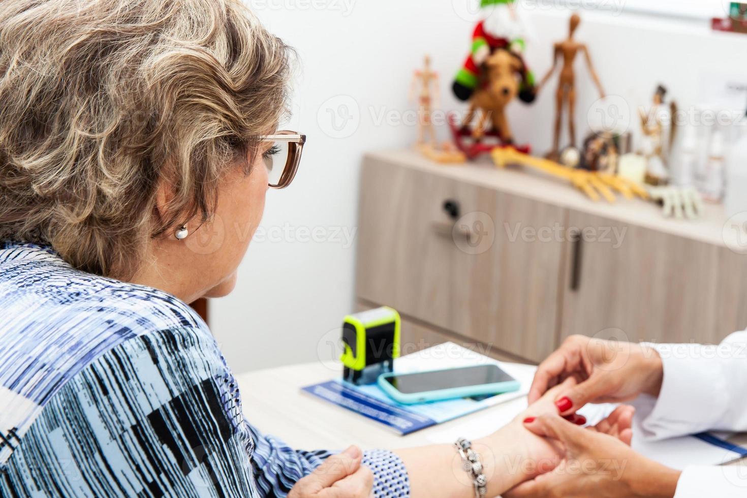 anziano femmina paziente nel consultazione con un' traumatologo femmina medico. scheletro osso malattia esame e medico aiuto. assicurazione concetto foto