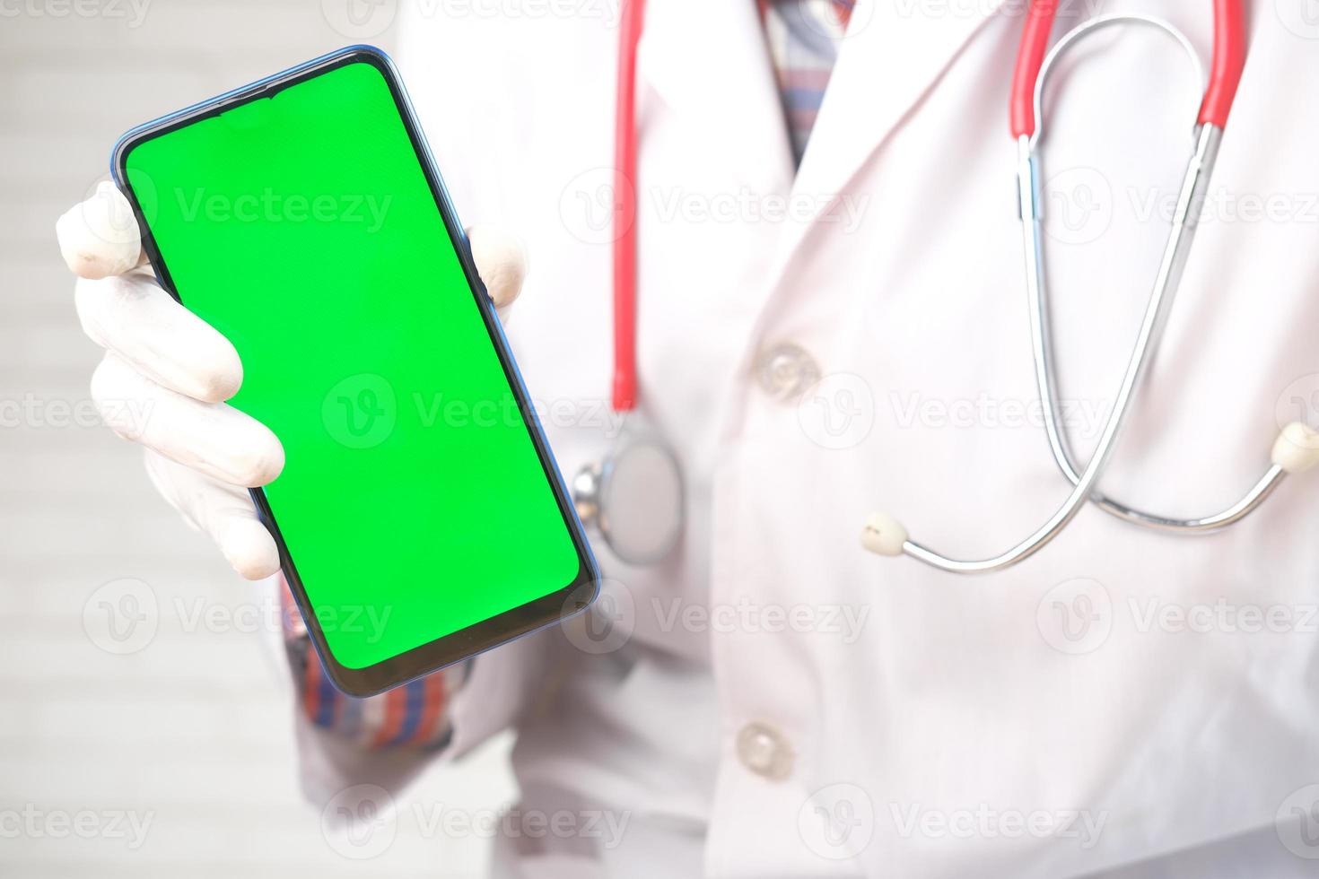 medico che tiene un modello di telefono foto