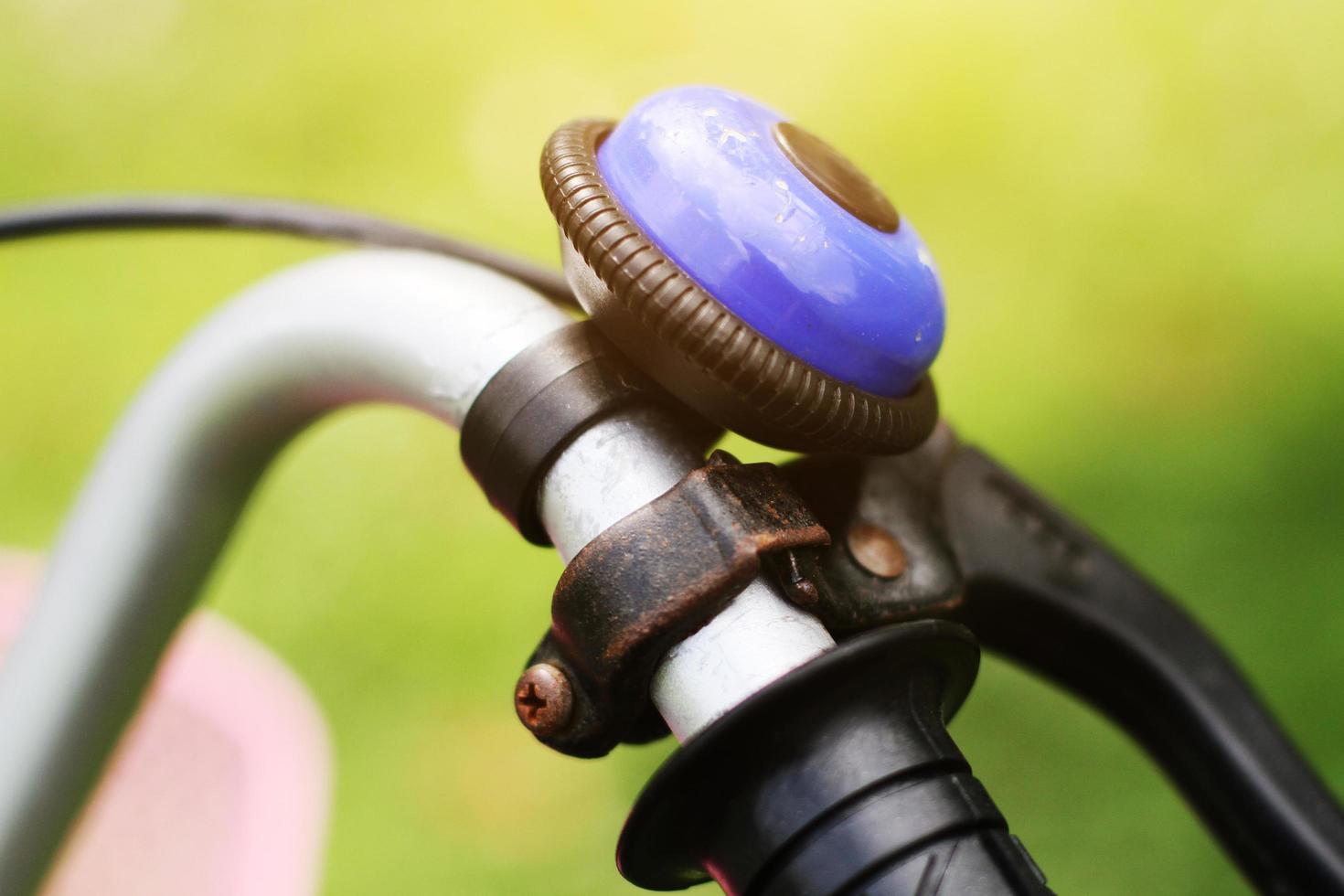 vecchio rusly e Vintage ▾ metallo blu campana su il manubrio di un vecchio bicicletta nel il parco foto