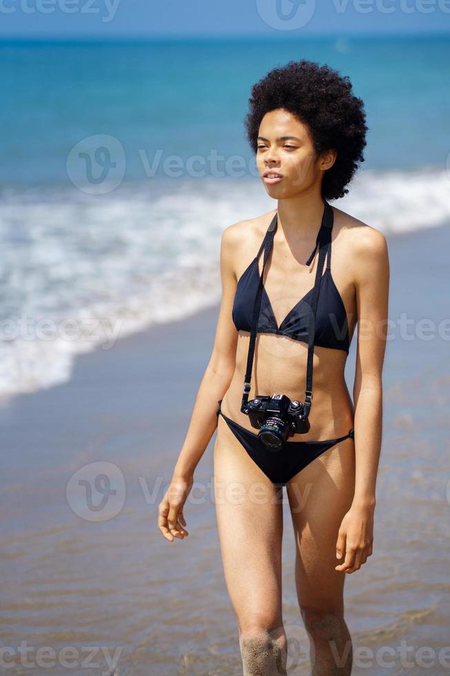 nero donna nel bikini con foto telecamera su riva del mare