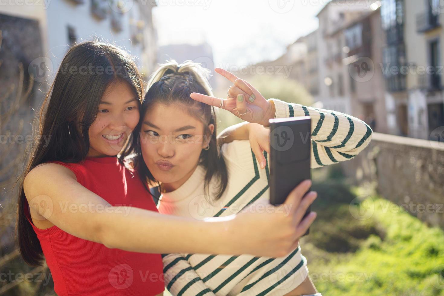 sorridente asiatico amiche assunzione autoscatto su strada foto