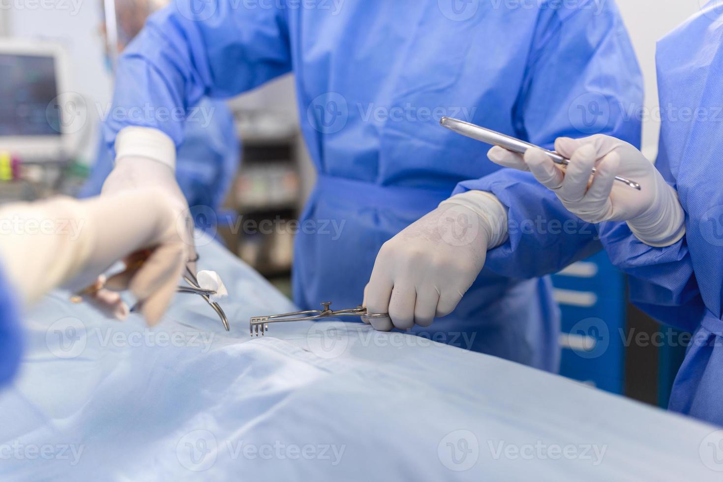 tiro nel il operativo camera, assistente mani su strumenti per chirurghi durante operazione. chirurghi eseguire operazione. professionale medico medici l'esecuzione chirurgia. foto