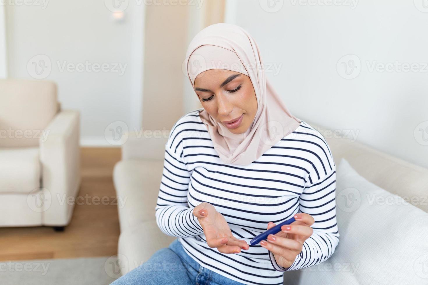 Arabo musulmano donna fare sangue zucchero test a casa nel un' vivente camera. foto