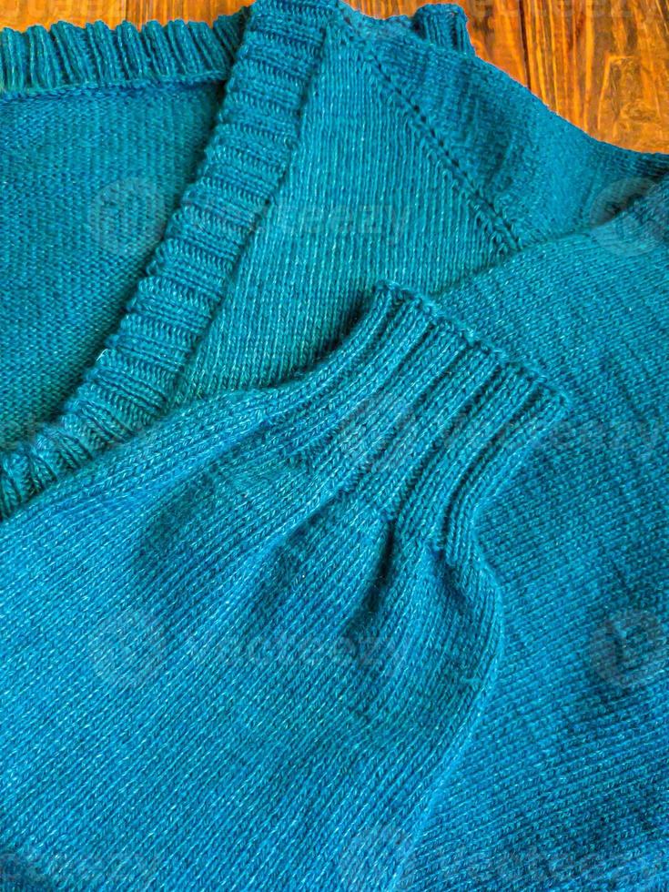 a maglia fatto a mano prodotti. a maglia tessuto di colorato discussioni nel il colore di benzina. Marrone sfondo. foto