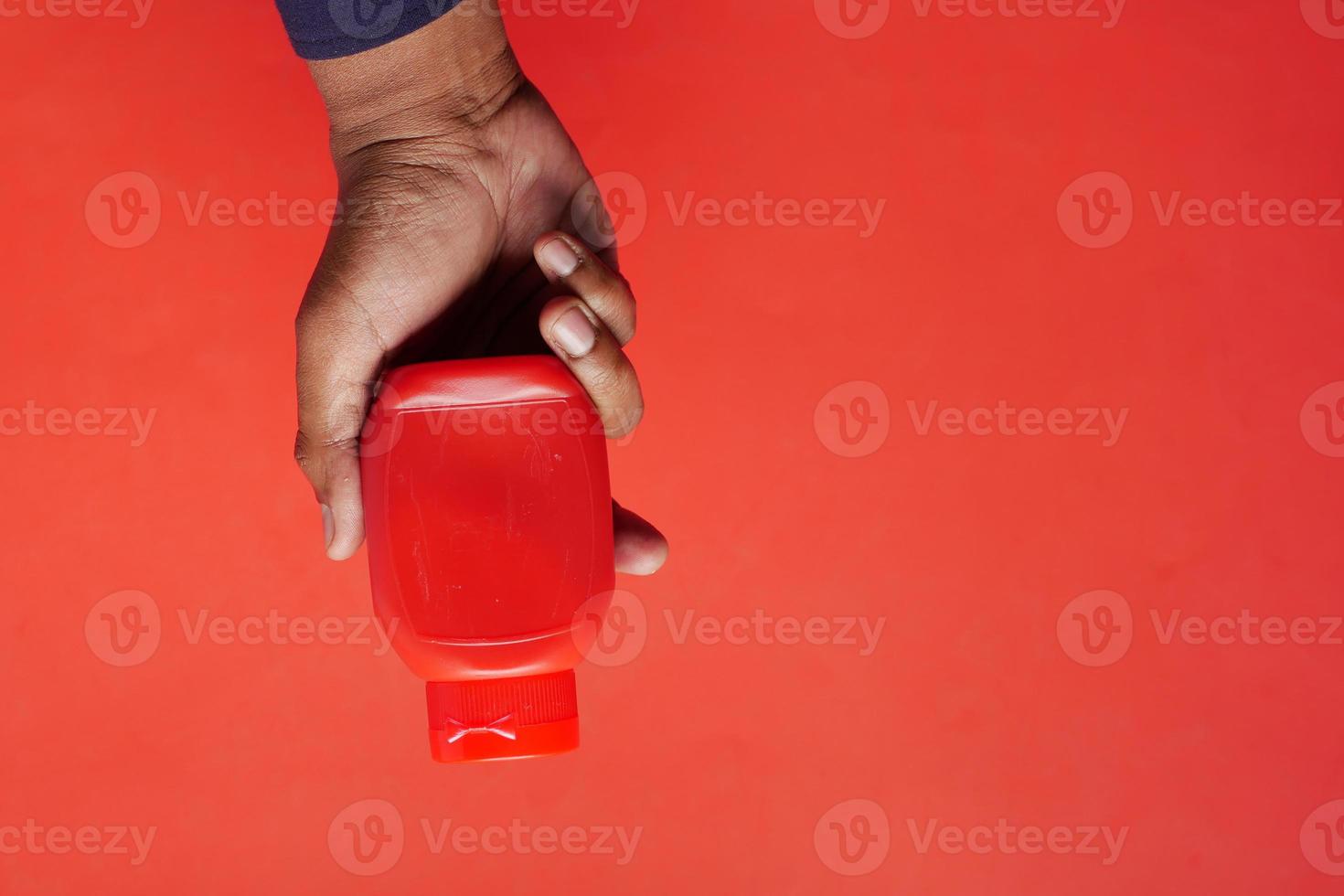 uomini Tenere un' pomodoro salsa bottiglia foto