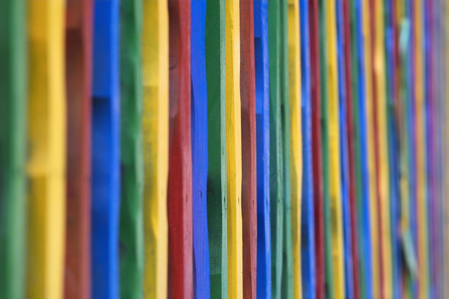 recinzione in legno colorato. una staccionata in legno fatta di bastoncini colorati foto