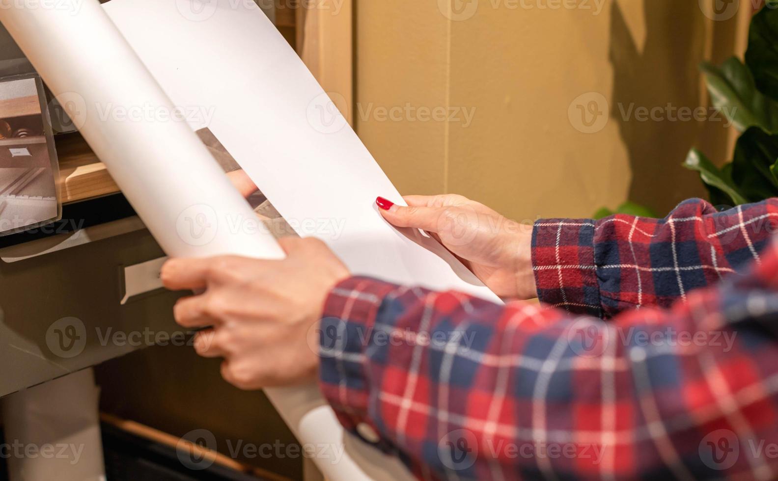 giovane donna Tenere un' grande carta, per Piano quello preparazione per opera a loro casa. foto