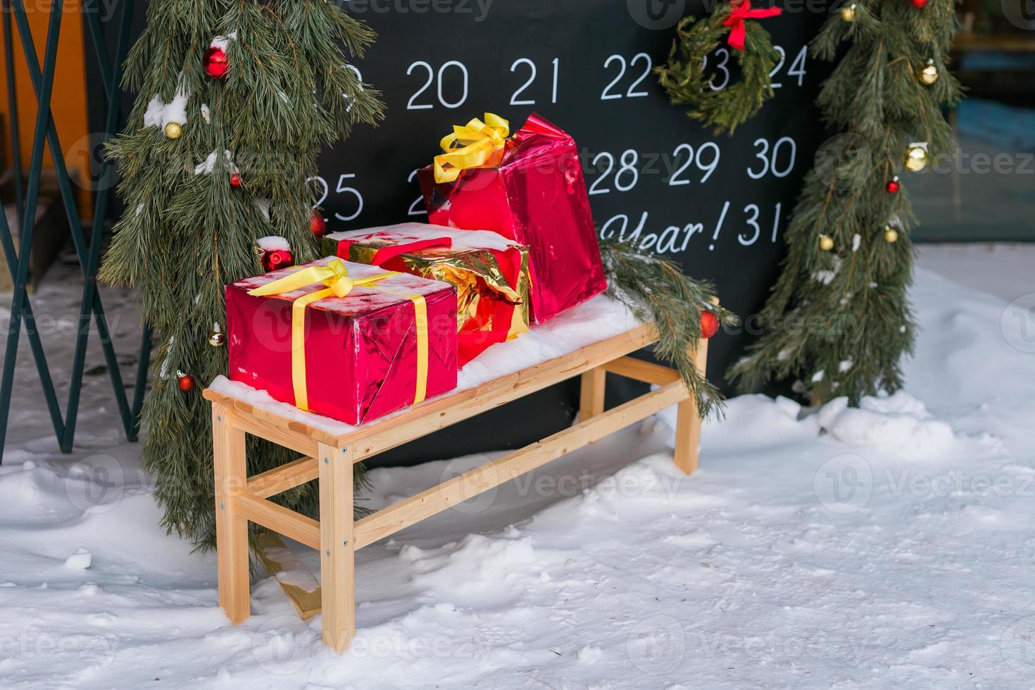 fatto a mano natale regalo scatole su panchina su neve. Natale vacanza celebrazione concetto foto