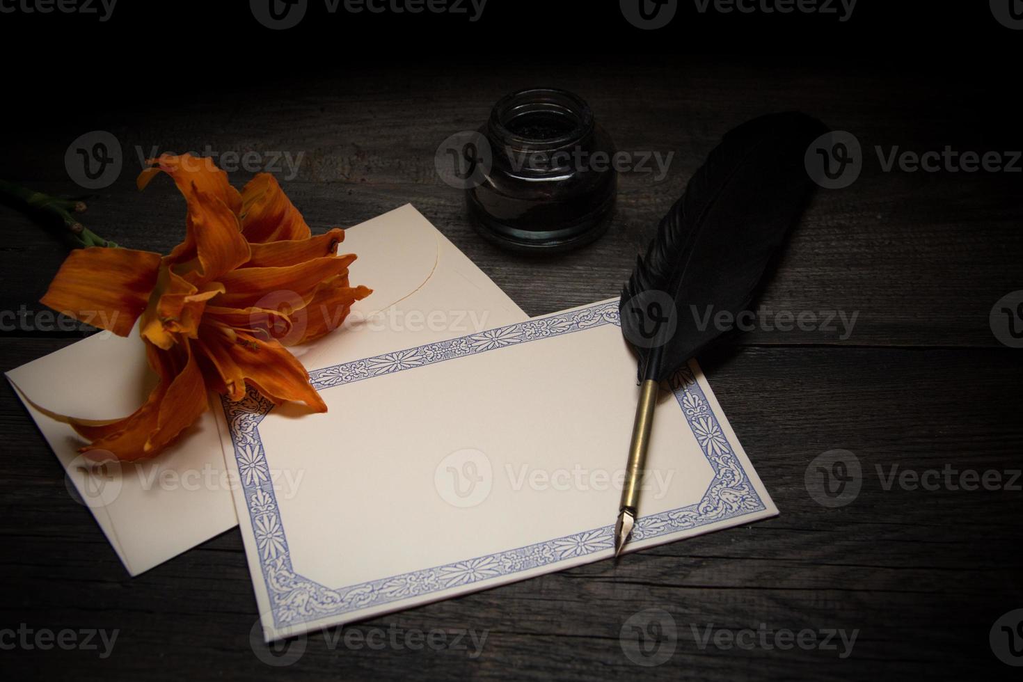un' foglio di vecchio carta con un' penna e un' fiore foto