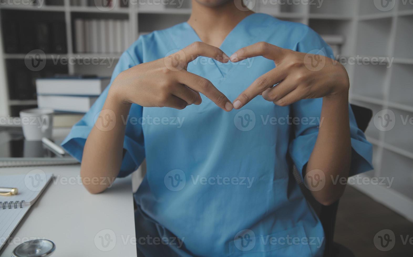 maschio medico in piedi con pollici su cartello nel clinica vicino il suo Lavorando posto. Perfetto medico servizio nel Ospedale. medicina e assistenza sanitaria concetto foto