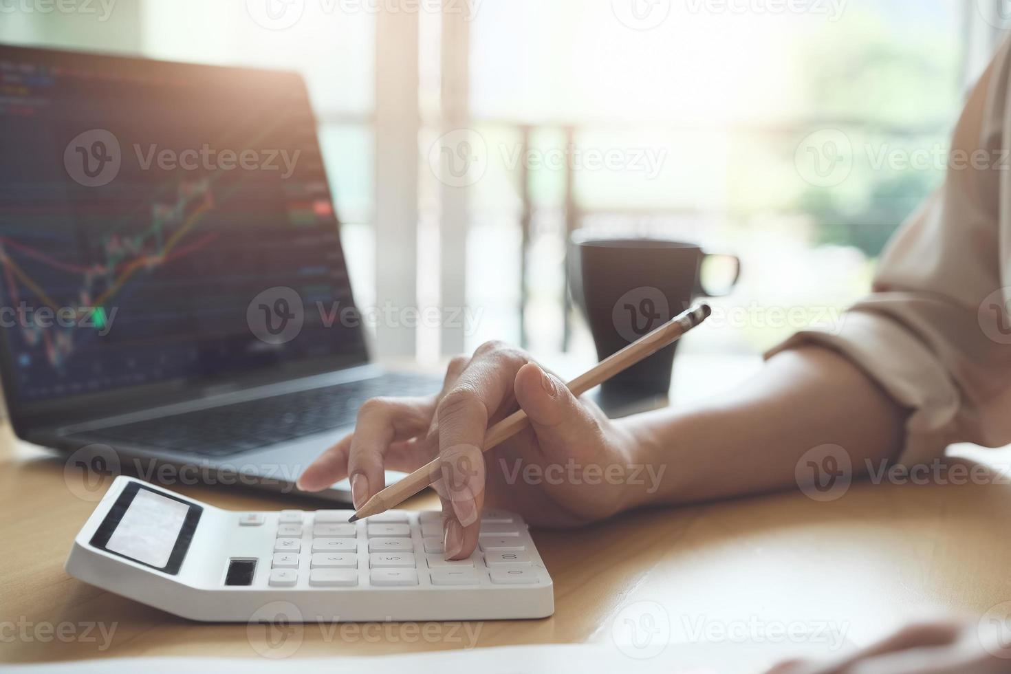 donna che utilizza una calcolatrice in un ufficio foto