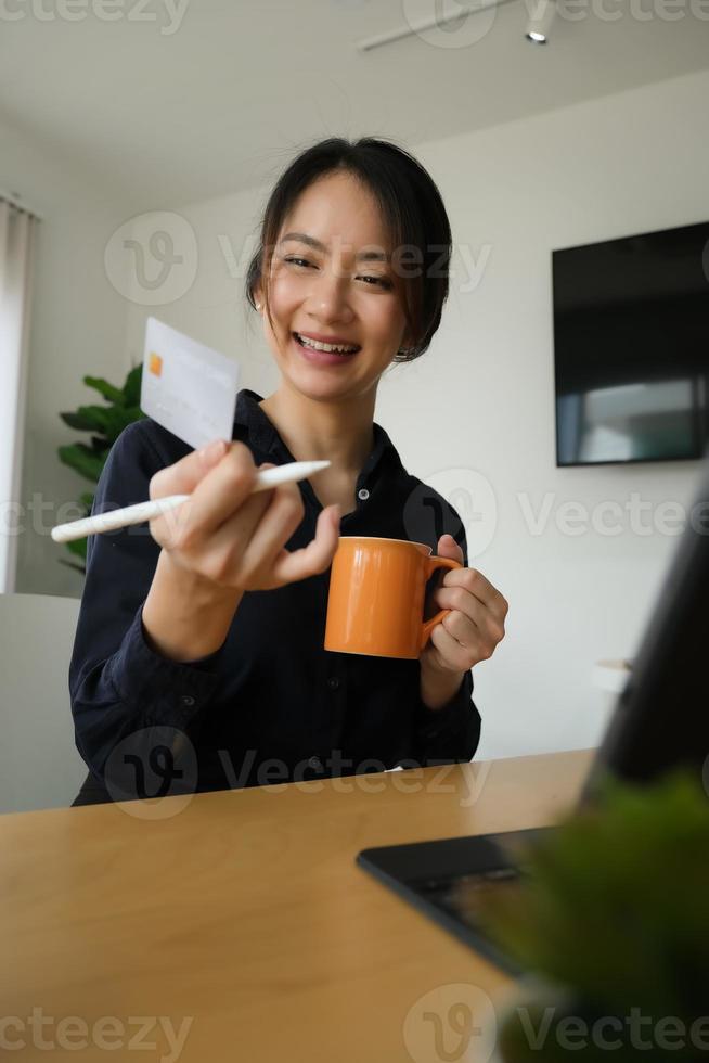 donna sorridente in possesso di una carta di credito foto