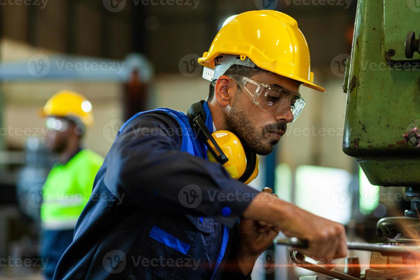 professionale ingegnere industriale lavoratori indossare giallo tute e sicurezza cappelli viso il telecamera nel un' fabbrica ambientazione. fabbrica Manutenzione e riparazione concetto foto