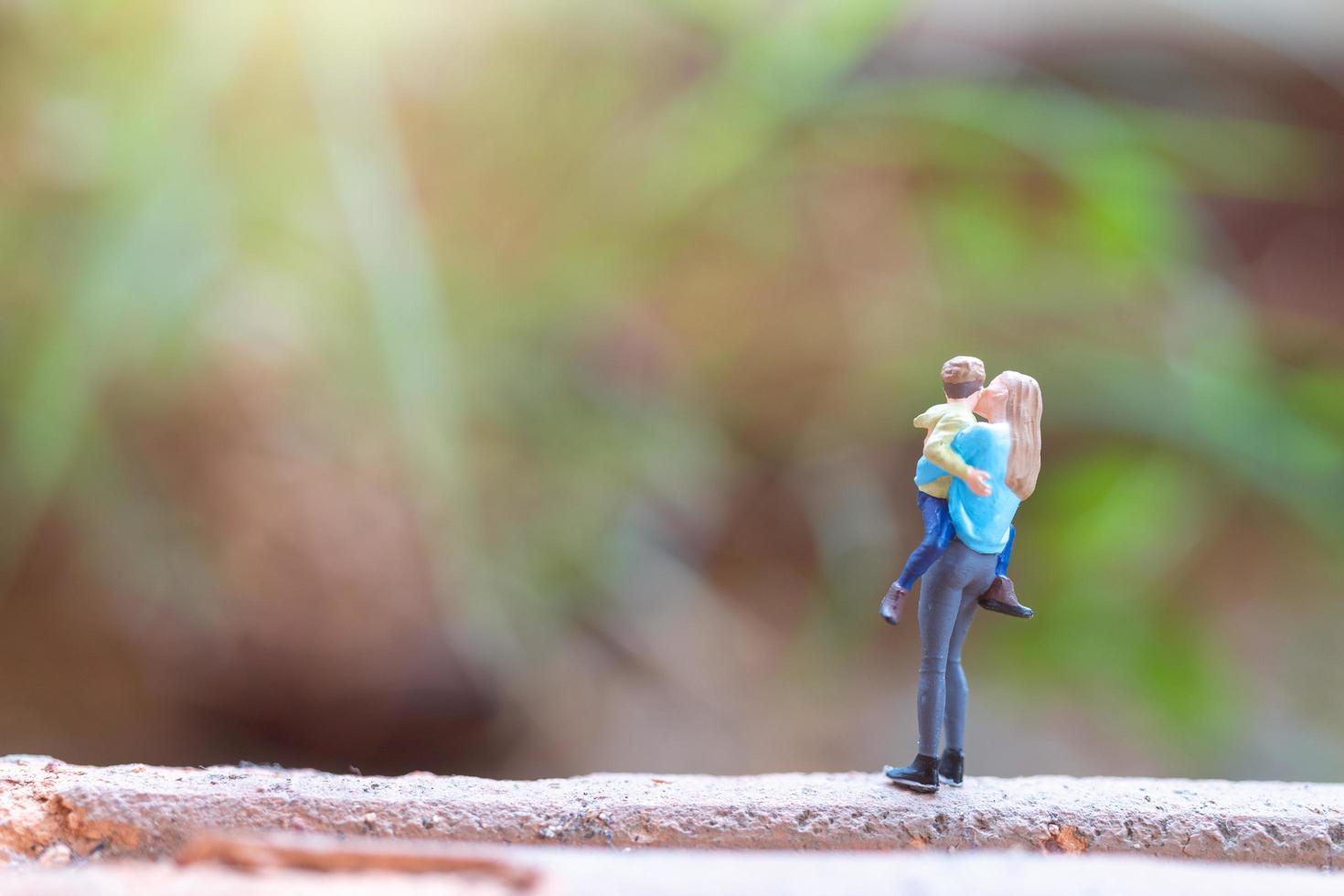 persone in miniatura, madre che tiene il suo bambino carino, concetto felice festa della mamma foto