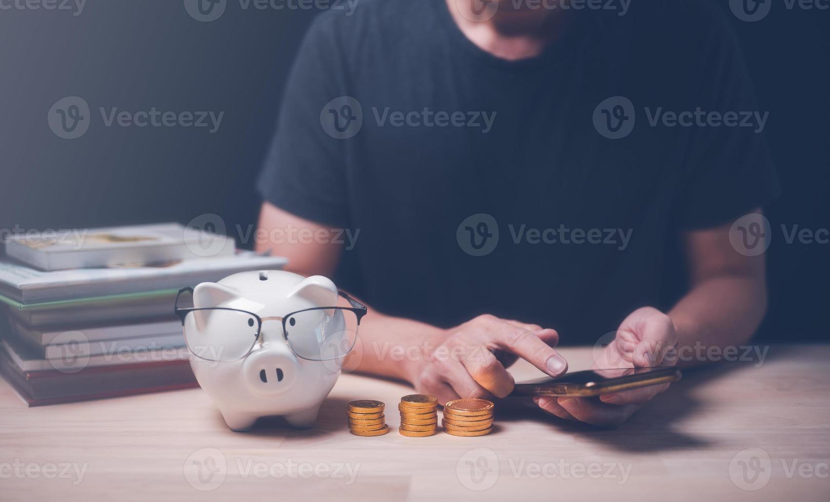 uomo utilizzando smartphone pianificazione per Salvataggio e investimento con giocare oro moneta e salvadanaio. casa bilancio, la pensione Piano foto