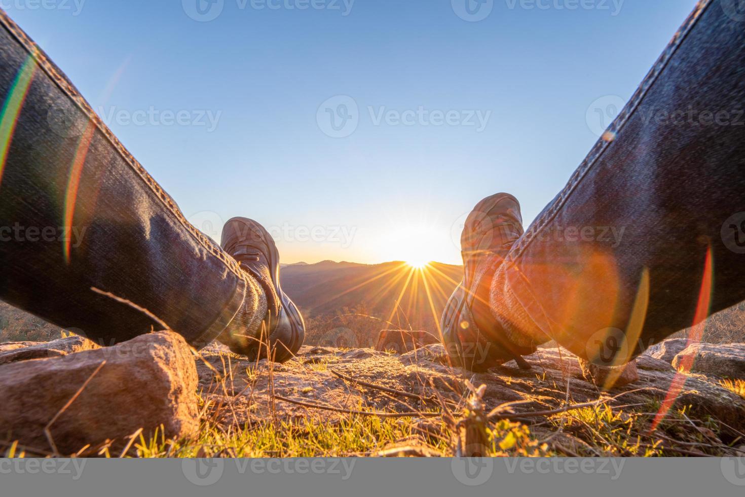 il sole tramonta tra le gambe di un uomo foto