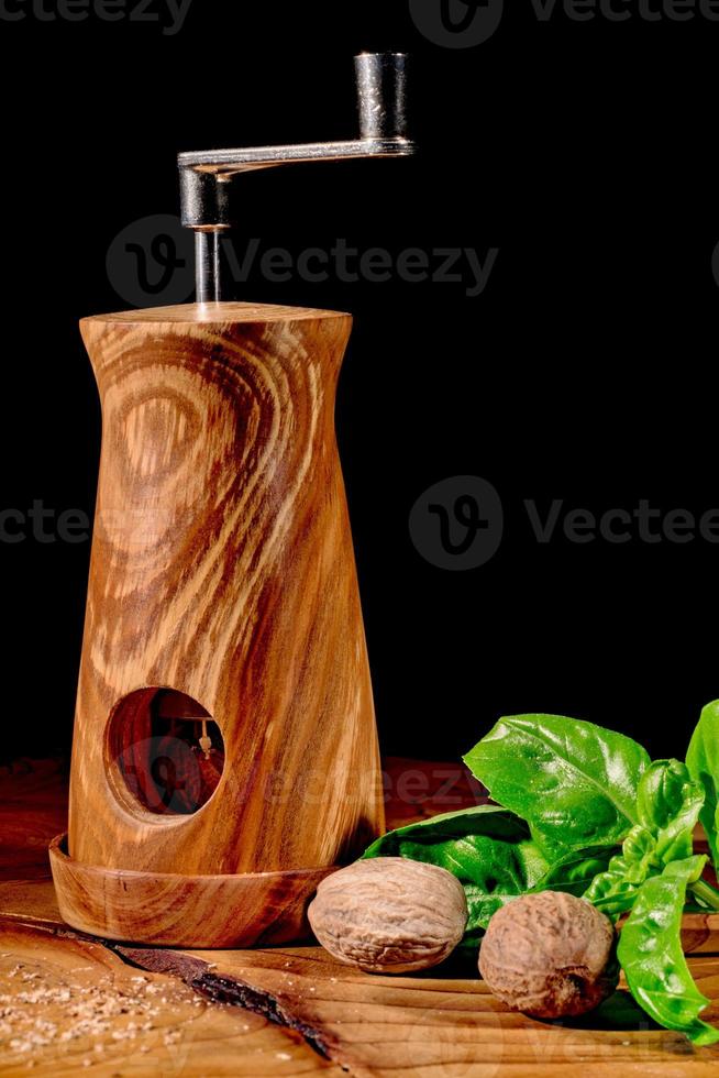 mulino moscato su tavola di legno con foglie di basilico, pomodoro, peperoncino e noce moscata foto