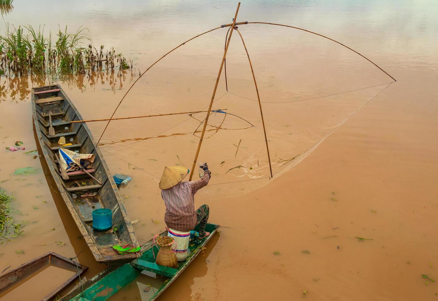 pescatore nel Mekong con antichi strumenti di pesca foto