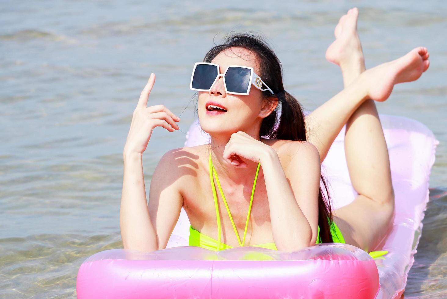 bella donna asiatica che gode del relax in spiaggia foto