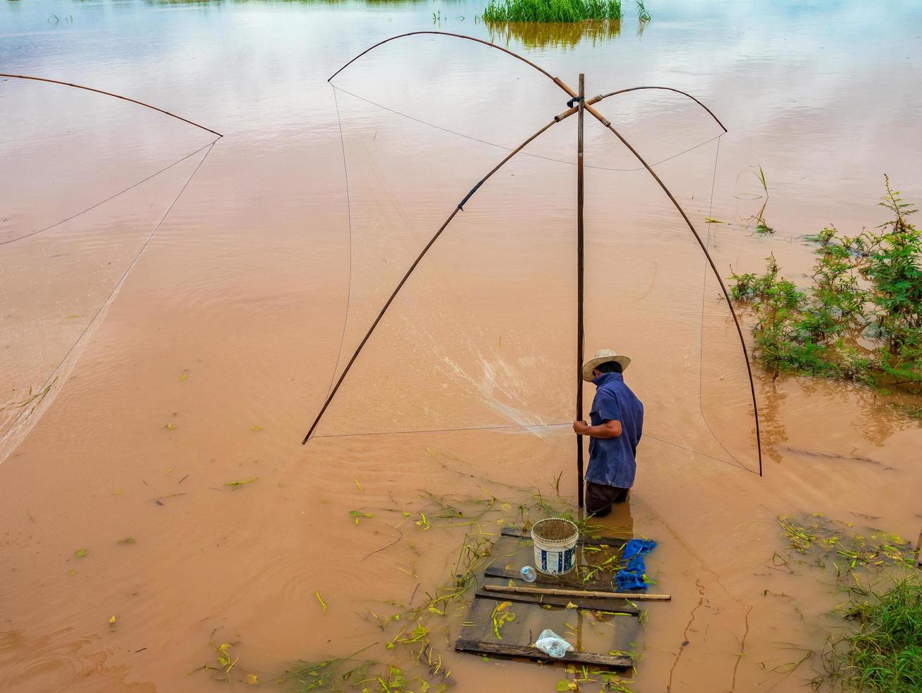 pescatore nel Mekong con antichi strumenti di pesca foto