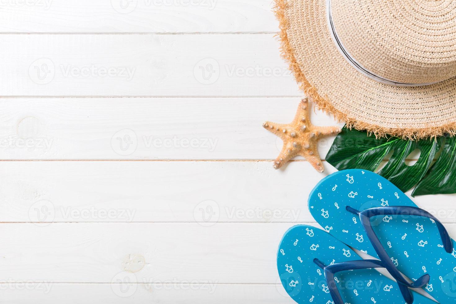 cannuccia cappello, verde foglia, blu Flip flop e stella marina su un' bianca di legno sfondo. superiore Visualizza estate vacanza concetto con copia spazio foto