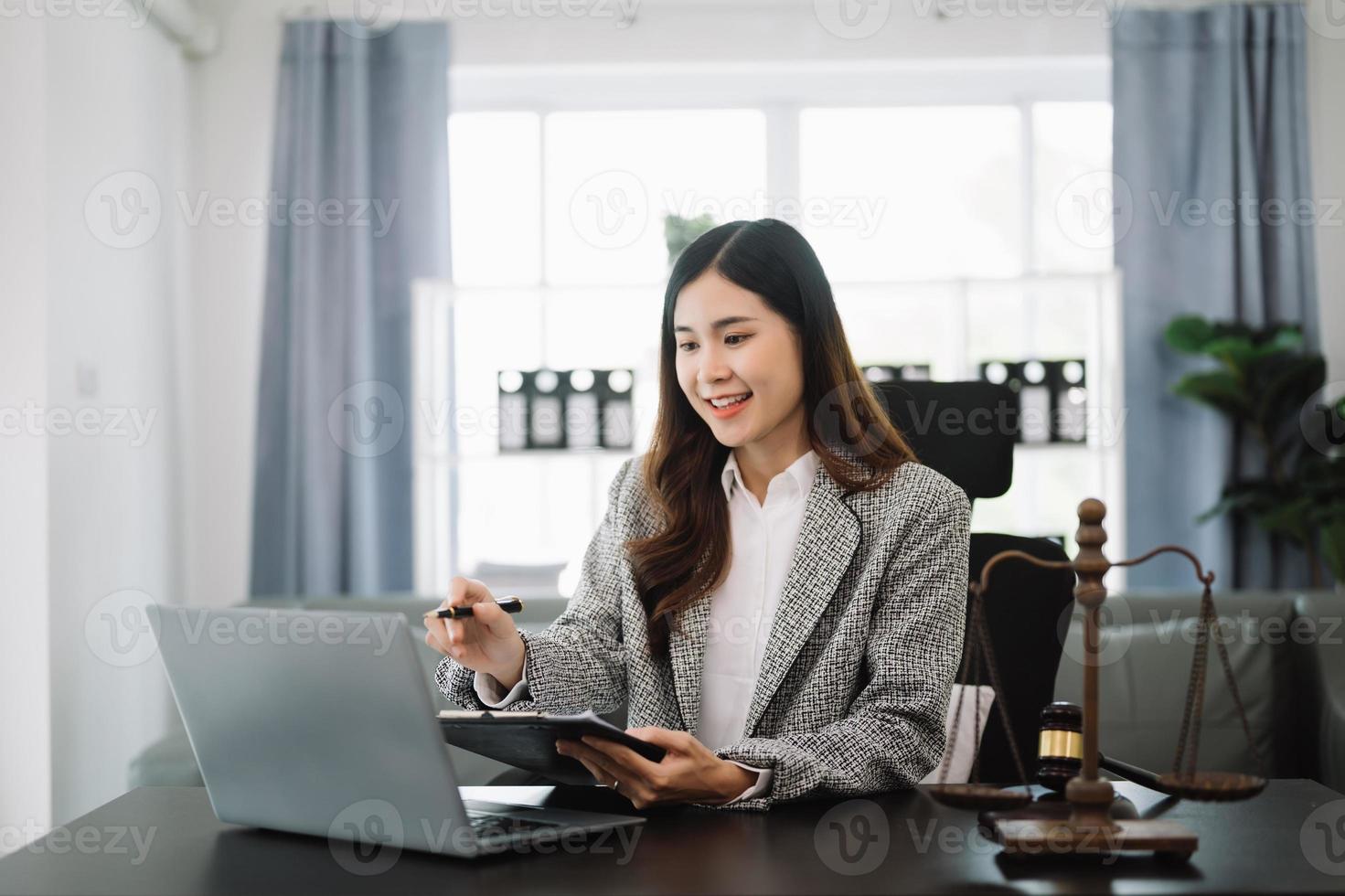 bellissimo asiatico donna avvocato Lavorando e martelletto, tavoletta, il computer portatile nel davanti, consigli giustizia e legge concetto. nel ufficio foto