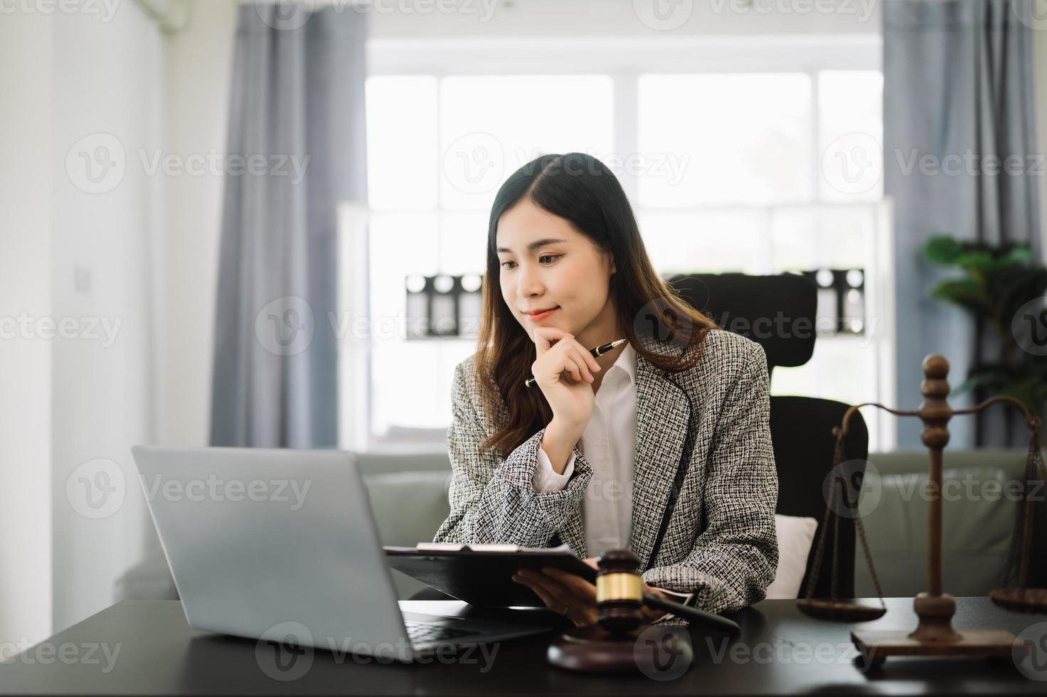 bellissimo asiatico donna avvocato Lavorando e martelletto, tavoletta, il computer portatile nel davanti, consigli giustizia e legge concetto. nel ufficio foto