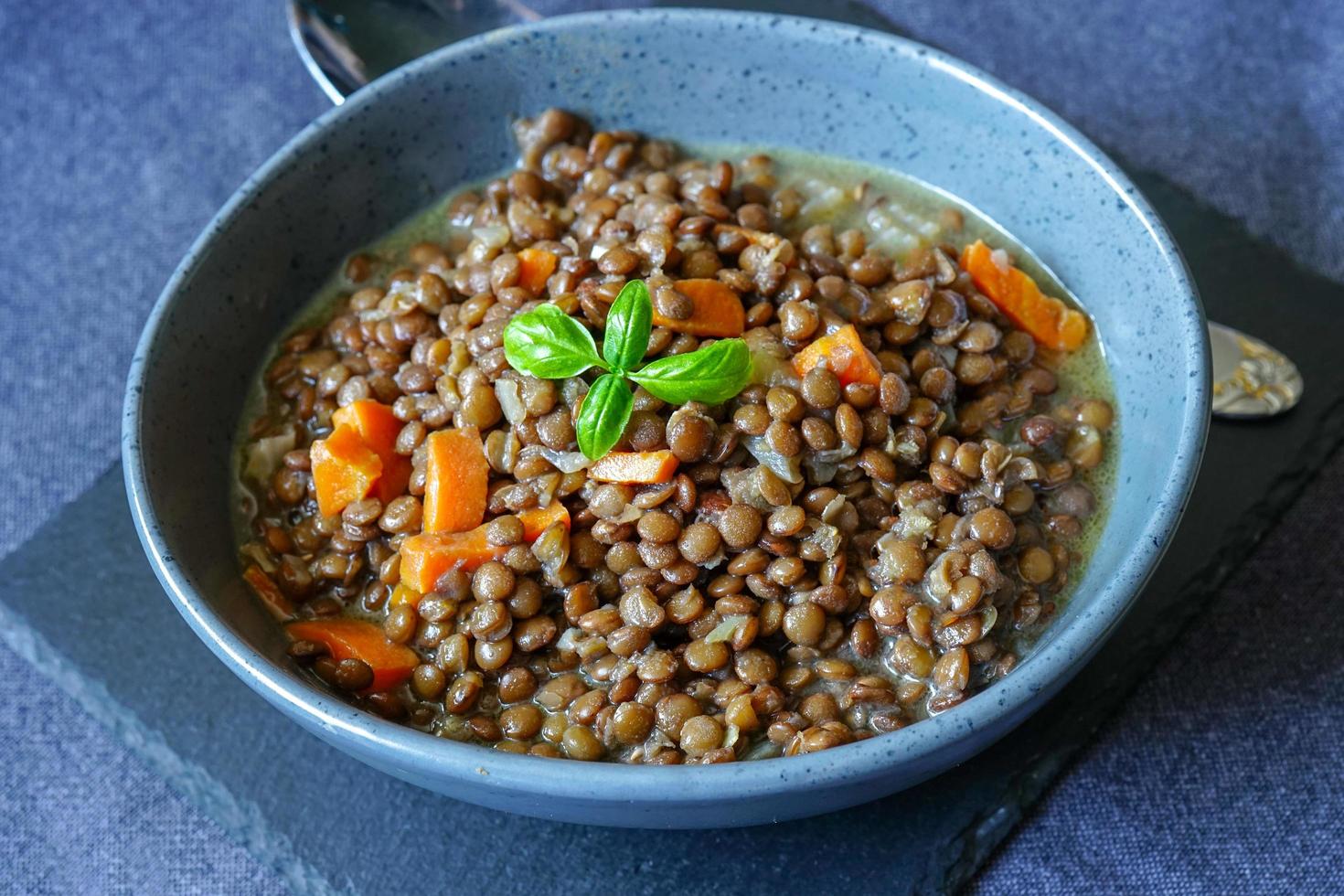 porridge di lenticchie in una ciotola di ceramica sul tavolo. foto