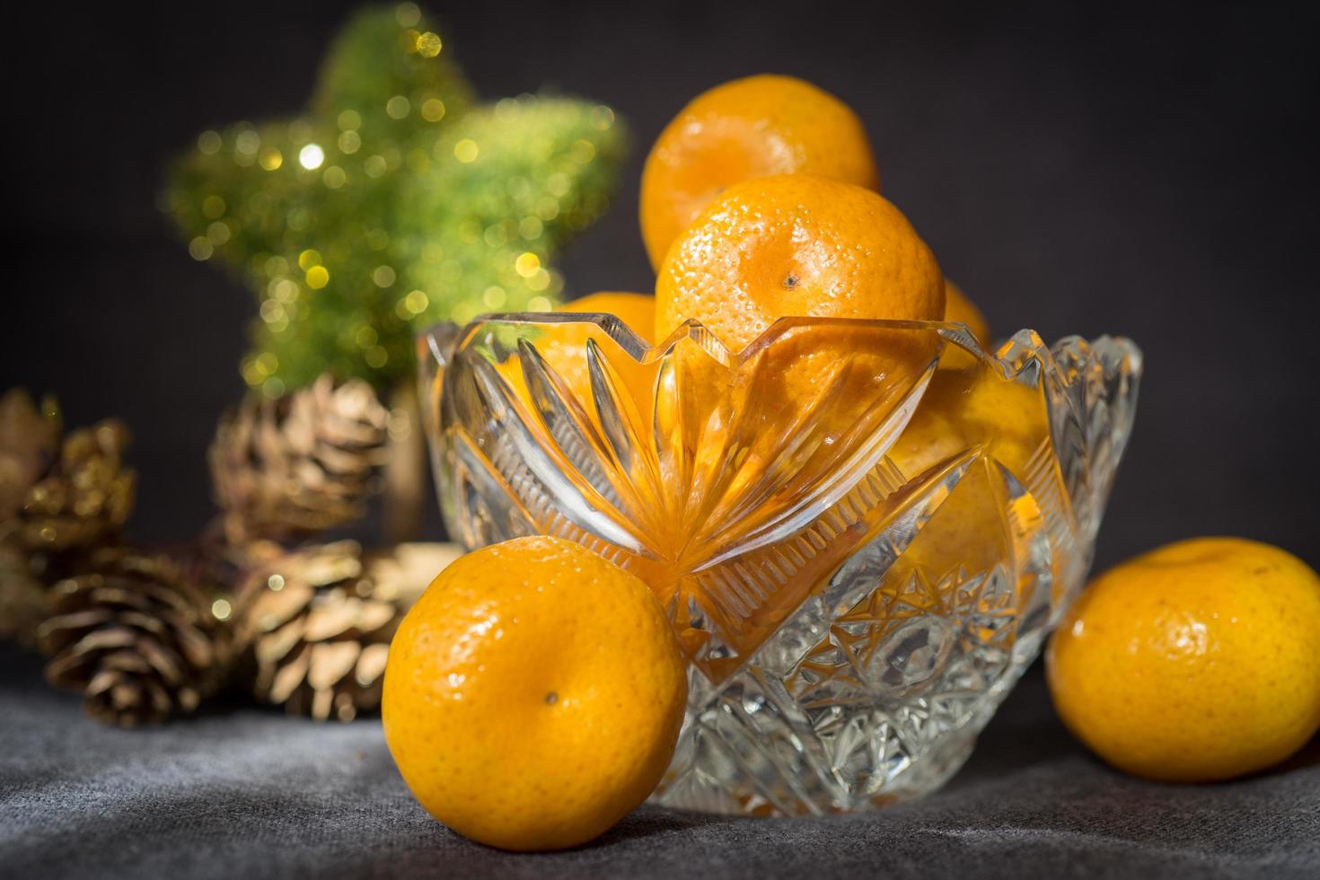 vaso di cristallo con un mandarino su sfondo grigio. foto