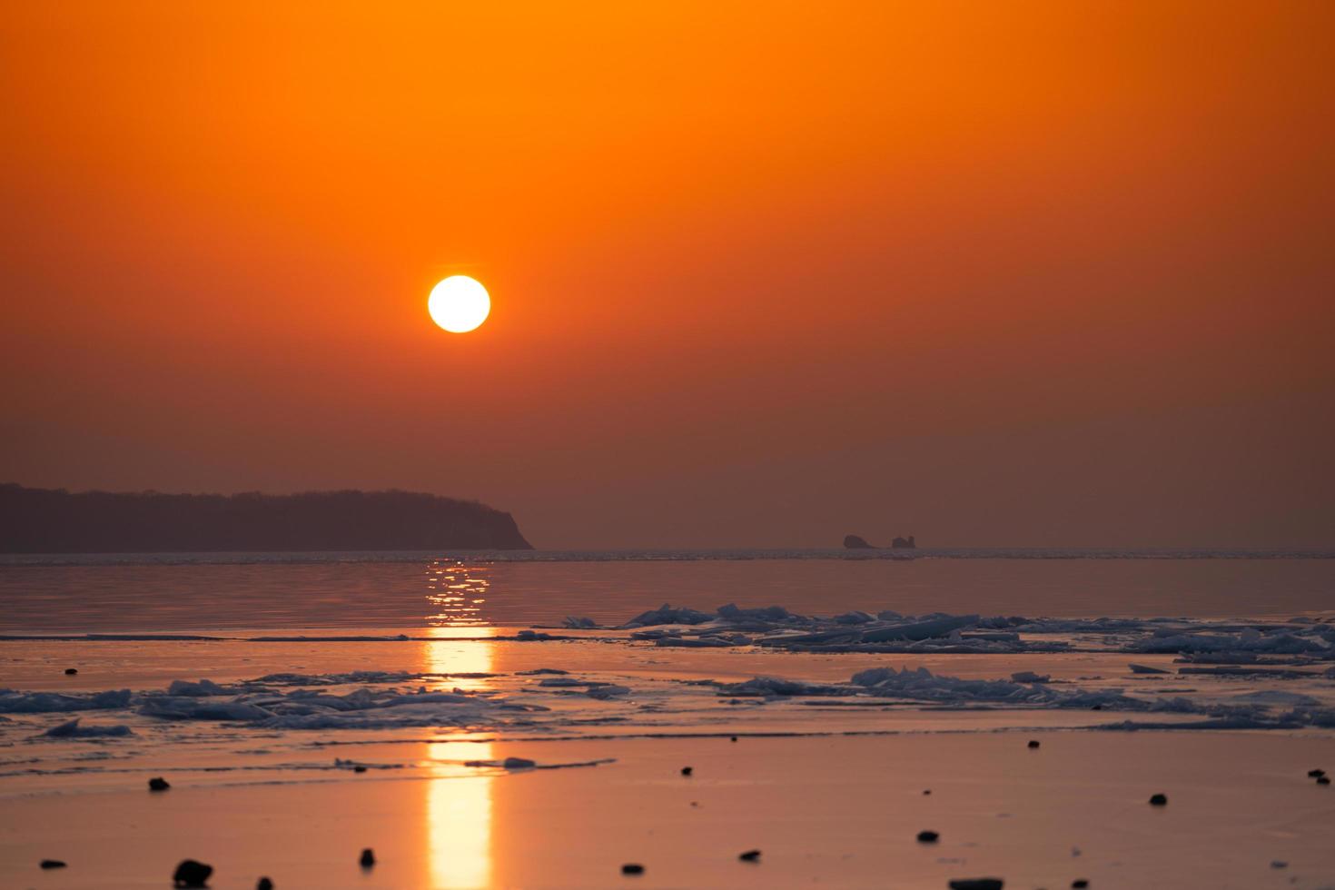 vista sul mare spiaggia di ghiaccio e il tramonto rosso. foto